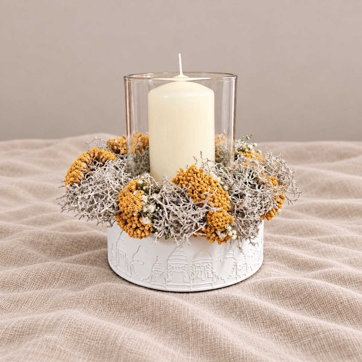 Windlicht Blütenzauber mit cremefarbener Kerze, gelben Trockenblumen und weißem Häuserrelief